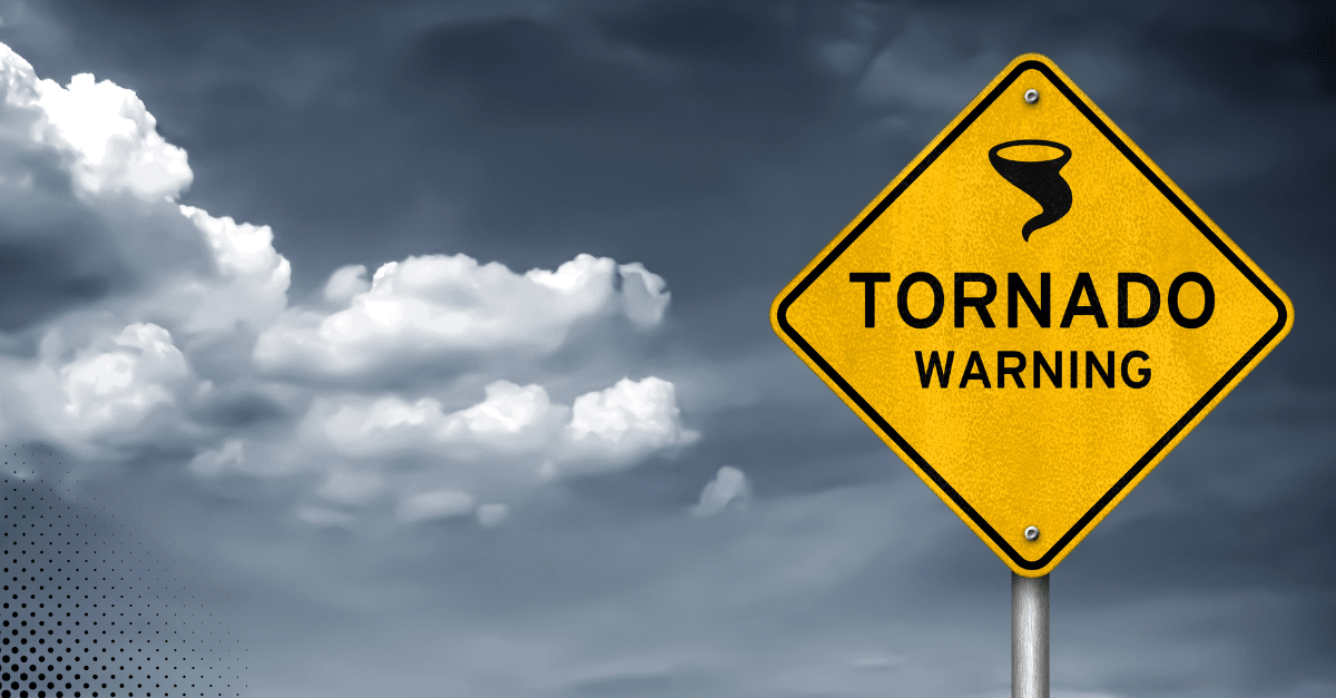 Tornado warning sign against a cloudy stormy sky.