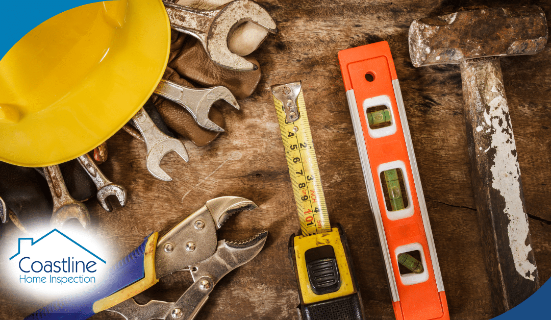 Tools for home inspection including pliers, wrenches, measuring tape, level, and hammer on wooden surface, featuring Coastline Home Inspection logo.